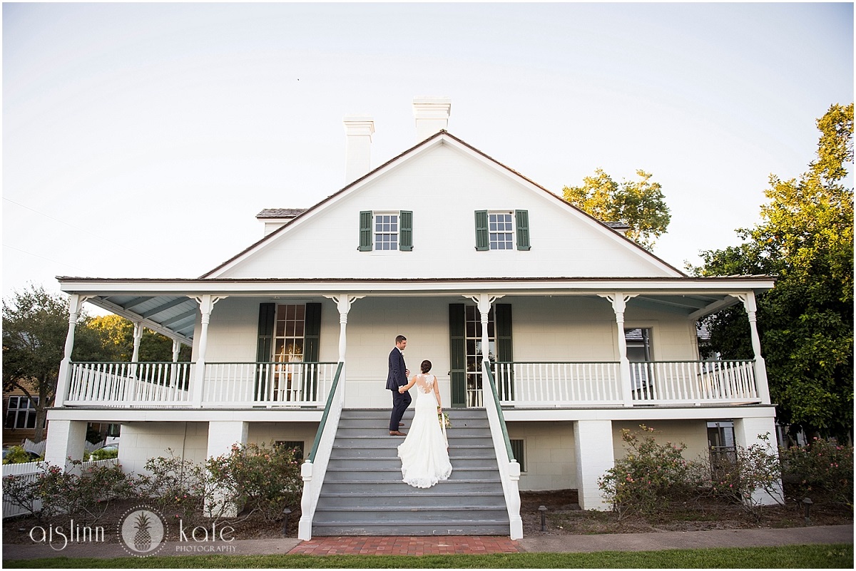 A photo of a bride and groom on the large stair case at the Barkley House.