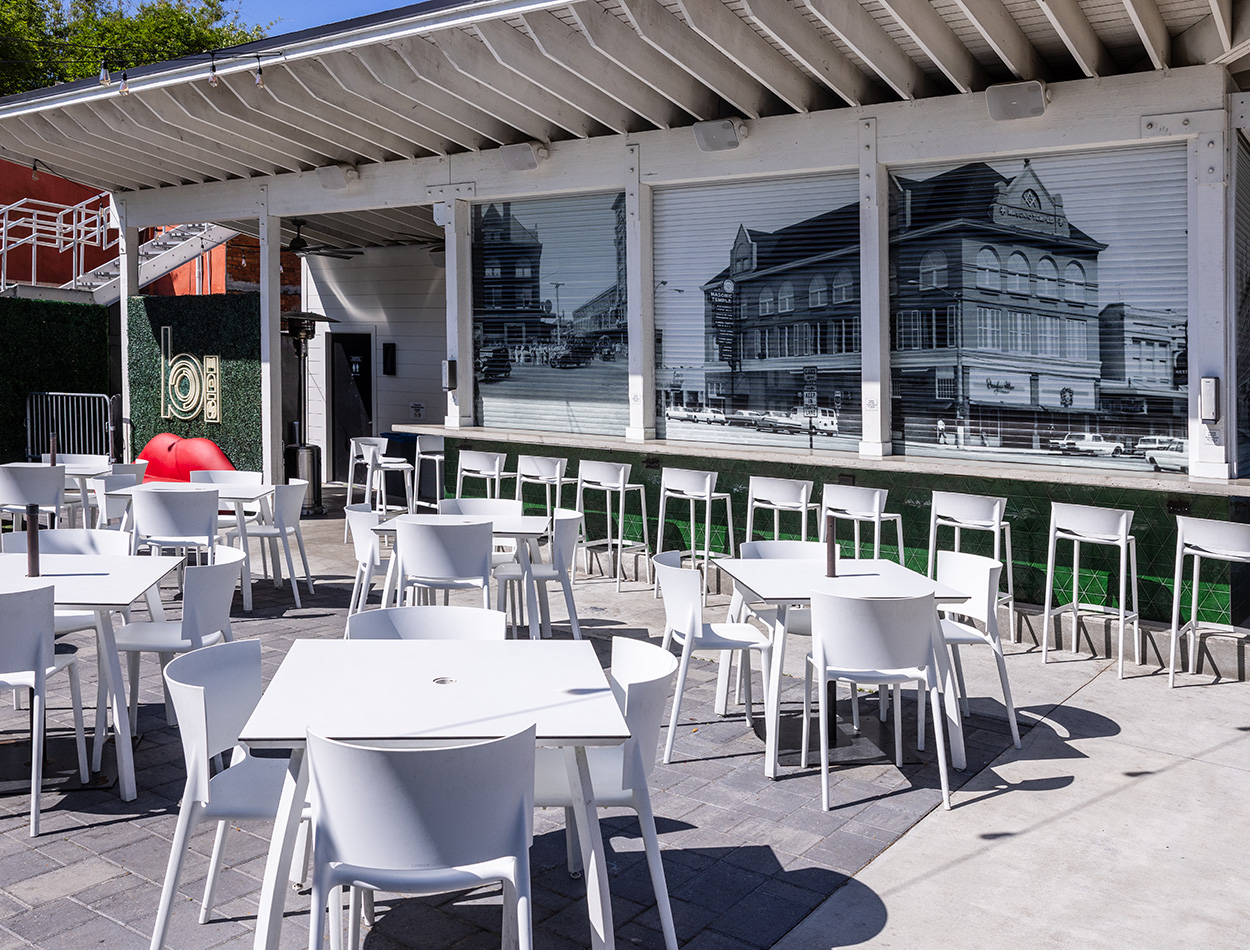 Outdoor seating with a wall display of an historic building mural.
