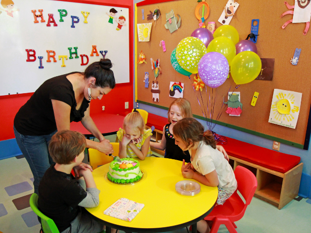 staff member helping children at the museum